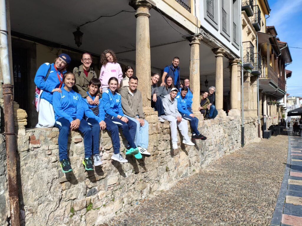 Deportistas y familias en los soportales del casco antiguo de Avilés.